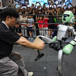 Un robot teledirigido de Unitree Robotics patea un trozo de madera durante la Conferencia Mundial de Inteligencia Artificial (WAIC) en el Centro Mundial de Exposiciones y Convenciones de Shanghái. | Foto:Hector Retamal / AFP