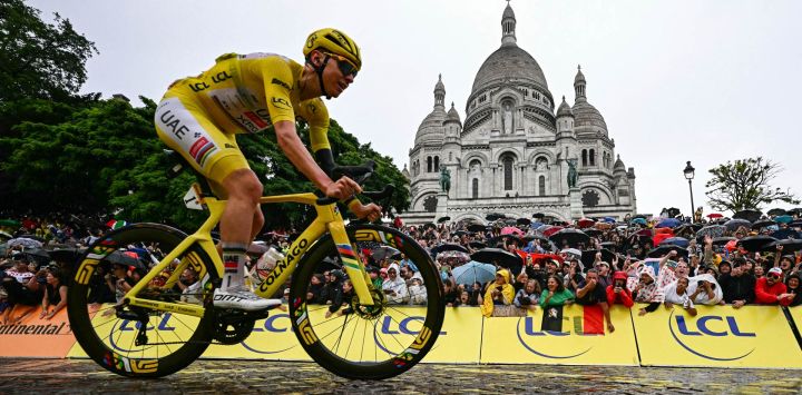 El ciclista esloveno Tadej Pogacar, del equipo UAE Team Emirates - XRG, luciendo el maillot amarillo de líder de la general, pasa en bicicleta junto a la Basílica del Sacré-Coeur en la Butte de Montmartre durante la 21.ª y última etapa de la 112.ª edición del Tour de Francia, de 132,3 km entre Mantes-la-Ville y la avenida de los Campos Elíseos de París.