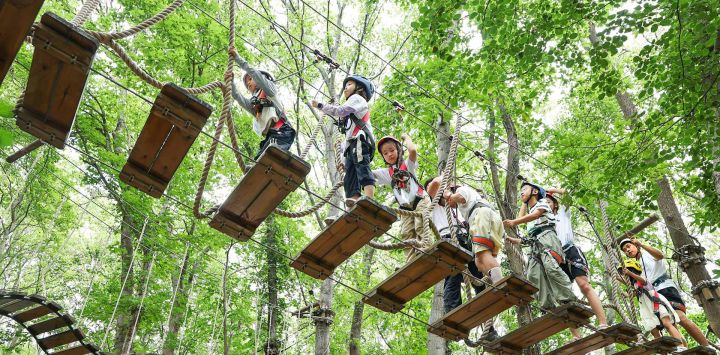 Niños participan en un juego de aventura al aire libre en un parque, en la ciudad de Lianyungang, en la provincia de Jiangsu, en el este de China. Niños participan en diversas actividades durante las vacaciones de verano en todo el país.