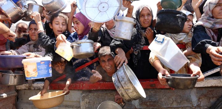 Palestinos se congregan en un punto de distribución de sopa de lentejas en la ciudad de Gaza, al norte de la Franja de Gaza.