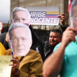 Imagen de personas sosteniendo carteles durante una audiencia del expresidente colombiano, Álvaro Uribe, frente al complejo judicial de Paloquemao, en Bogotá, capital de Colombia. Uribe Vélez (2002-2010) fue declarado culpable por los delitos de soborno en actuación penal y fraude procesal, en el complejo judicial de Paloquemao ubicado en Bogotá, convirtiéndose en el primer exmandatario en Colombia en ser condenado por un cargo penal. | Foto:Xinhua/Andrés Moreno