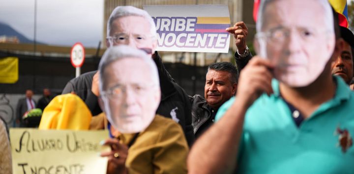 Imagen de personas sosteniendo carteles durante una audiencia del expresidente colombiano, Álvaro Uribe, frente al complejo judicial de Paloquemao, en Bogotá, capital de Colombia. Uribe Vélez (2002-2010) fue declarado culpable por los delitos de soborno en actuación penal y fraude procesal, en el complejo judicial de Paloquemao ubicado en Bogotá, convirtiéndose en el primer exmandatario en Colombia en ser condenado por un cargo penal.