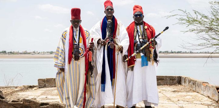 Los sumos sacerdotes de la comunidad Lebou, Moussa Niang (der.), Bakou Mory Mbaye (centro) y Hassan Kone (izq.), posan para un retrato durante una ceremonia de adivinación Xooy en Fatick. Cada año, con la llegada de la temporada de lluvias, una veintena de adivinos, más conocidos en Senegal como Saltigues, se turnaban para ofrecer sus predicciones sobre los eventos que podrían ocurrir en el país a lo largo del año durante una ceremonia de adivinación llamada "Xooy".