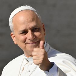 El papa León XIV hace un gesto al llegar a la audiencia general semanal en la plaza de San Pedro del Vaticano. | Foto:ALBERTO PIZZOLI / AFP