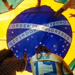 Manifestantes exhiben una gran bandera brasileña durante un evento en apoyo a la soberanía nacional, celebrado en el Salón Noble de la Facultad de Derecho de la USP en São Paulo, Brasil. | Foto:MIGUEL SCHINCARIOL / AFP