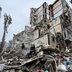 Trabajadores de emergencia ucranianos entre los escombros de un edificio residencial tras un ataque aéreo en Kiev, en medio de la invasión rusa de Ucrania. | Foto:Sergii Volski / AFP