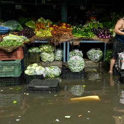 Vendedores de verduras preparan sus provisiones mientras esperan a los clientes en una calle inundada tras fuertes lluvias en Amritsar, India. | Foto:Narinder Nanu / AFP