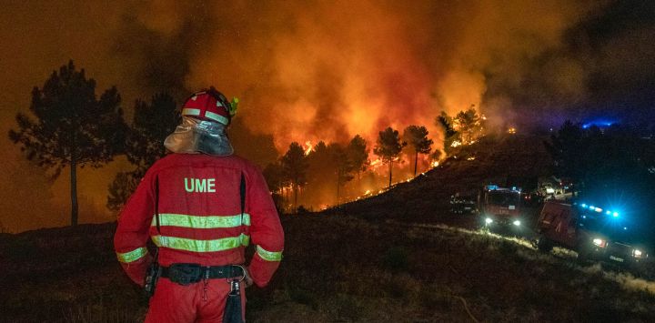 Esta foto, publicada por la Unidad Militar de Emergencias (UME), muestra a bomberos combatiendo un incendio forestal cerca de Caminomorisco, en la provincia de Cáceres, al oeste de España.