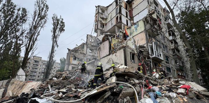 Trabajadores de emergencia ucranianos entre los escombros de un edificio residencial tras un ataque aéreo en Kiev, en medio de la invasión rusa de Ucrania.