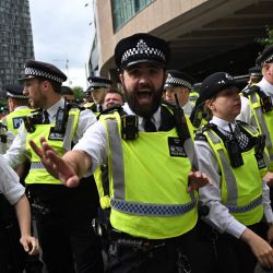 La policía se enfrenta a manifestantes durante una protesta frente al Hotel Britannia en Canary Wharf por su uso para albergar a solicitantes de asilo. | Foto:JUSTIN TALLIS / AFP