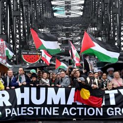 Manifestantes marchan por el Puente del Puerto de Sídney durante una manifestación pro palestina contra las acciones de Israel y la escasez de alimentos en la Franja de Gaza, en Sídney. | Foto:Saeed Khan / AFP