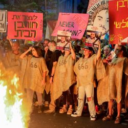 Manifestantes se congregan ante una hoguera durante una protesta antigubernamental para exigir la liberación de los rehenes israelíes retenidos en la Franja de Gaza por militantes palestinos desde los atentados del 7 de octubre de 2023. | Foto:JACK GUEZ / AFP