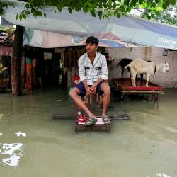 Un hombre se sienta frente a su casa, parcialmente inundada por las fuertes lluvias monzónicas que provocaron un aumento del nivel del río Ganges en Varanasi, India. | Foto:NIHARIKA KULKARNI / AFP