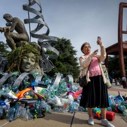 Una mujer se toma una selfi frente a la obra del artista, activista y fotógrafo canadiense Benjamin Von Wong, titulada "La Carga del Pensador", una remezcla escultórica de 6 metros de altura del icónico Pensador de Rodin, creada para las negociaciones del Tratado sobre los Plásticos. | Foto:FABRICE COFFRINI / AFP
