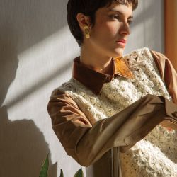 Chaleco con flores tejido a mano con lana de mohair de una pequeña cooperativa de la Patagonia (Maydi). Camisa oversize de hombre inglesa, teñida a mano y con botones de cuero de antiguas Botanguitas. Prenda única. (Hahnmade). Aro de bronce y plata reutilizada (Limido Joyas).