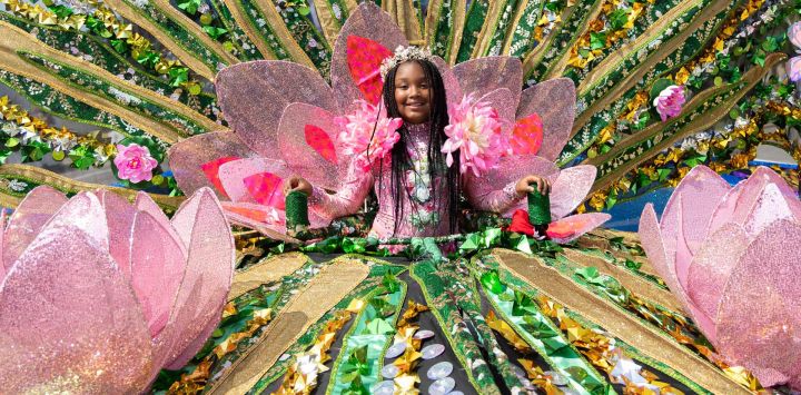 Imagen de una niña disfrazada posando para fotografías con su carroza durante el Gran Desfile del Carnaval Caribeño de Toronto 2025, en Toronto, Canadá.