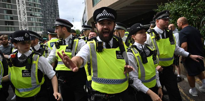 La policía se enfrenta a manifestantes durante una protesta frente al Hotel Britannia en Canary Wharf por su uso para albergar a solicitantes de asilo.