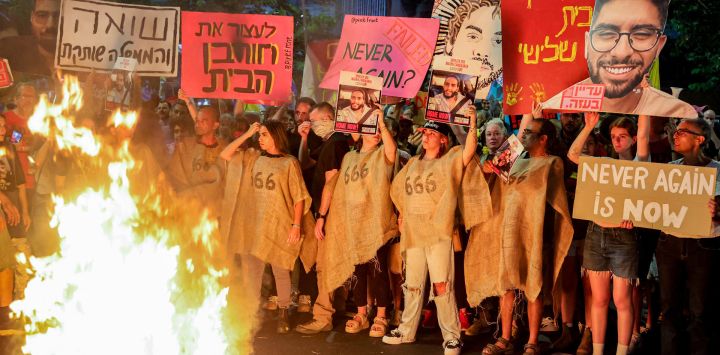 Manifestantes se congregan ante una hoguera durante una protesta antigubernamental para exigir la liberación de los rehenes israelíes retenidos en la Franja de Gaza por militantes palestinos desde los atentados del 7 de octubre de 2023.
