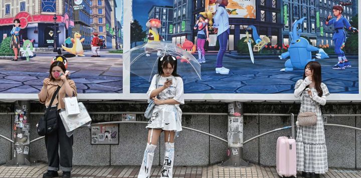Mujeres jóvenes frente a un anuncio del gigante japonés de videojuegos Nintendo, frente a la estación de Shibuya, en el centro de Tokio. Nintendo reportó un aumento interanual del 132 % en sus ingresos trimestrales gracias a la Switch 2, que se convirtió en la consola de mayor venta en el mundo tras su lanzamiento en junio.