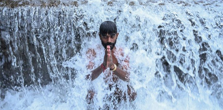 Un devoto se da un baño sagrado en el río Bagmati antes de ofrecer oraciones al dios hindú Shiva en el templo Pashupatinath durante las festividades de Shravan en las afueras de Katmandú, India.