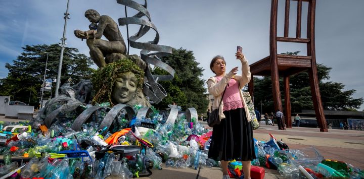 Una mujer se toma una selfi frente a la obra del artista, activista y fotógrafo canadiense Benjamin Von Wong, titulada "La Carga del Pensador", una remezcla escultórica de 6 metros de altura del icónico Pensador de Rodin, creada para las negociaciones del Tratado sobre los Plásticos.