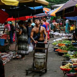 Un trabajador empuja un carrito junto a productos frescos en un mercado callejero de Yangon, Myanmar. | Foto:Sai Aung Main / AFP