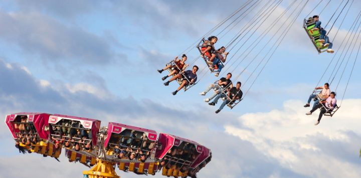 Imagen de personas disfrutando de los juegos mecánicos en la feria "Sivarland", por la temporada vacacional de las Fiestas Agostinas, en el departamento de San Salvador, capital de El Salvador.