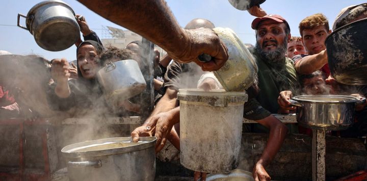 Palestinos reciben sopa de lentejas en un punto de distribución de alimentos en la ciudad de Gaza. La Organización Mundial de la Salud advirtió que la desnutrición estaba alcanzando niveles alarmantes en Gaza.