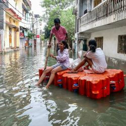 Niños viajan en un muelle flotante en una zona residencial inundada después de que las fuertes lluvias monzónicas provocaran un aumento del nivel del agua del río Ganges en Varanasi, India. | Foto:NIHARIKA KULKARNI / AFP