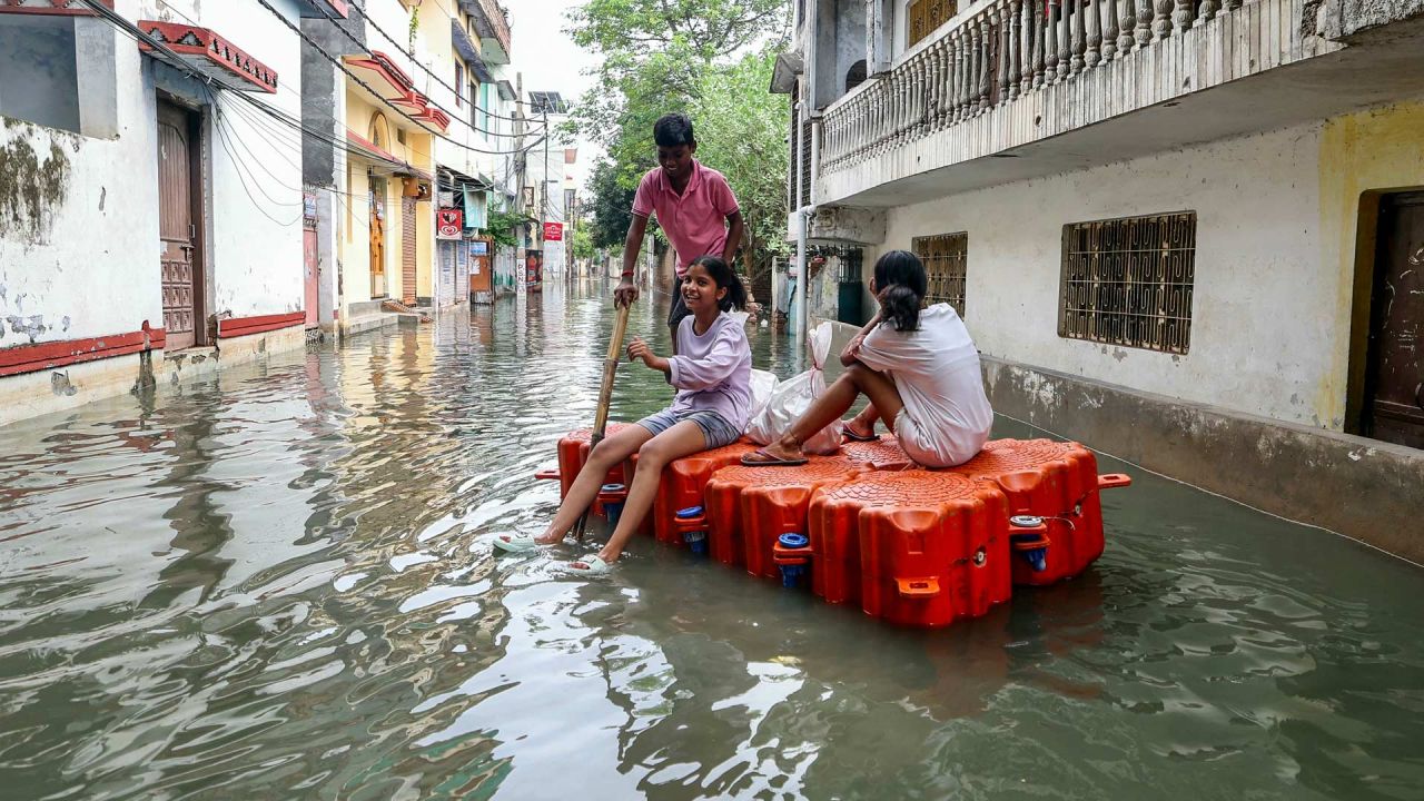 Niños viajan en un muelle flotante en una zona residencial inundada después de que las fuertes lluvias monzónicas provocaran un aumento del nivel del agua del río Ganges en Varanasi, India. | Foto:NIHARIKA KULKARNI / AFP