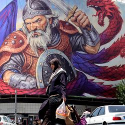 Una mujer camina representando una escena del poema épico nacional iraní "Shahnameh" en Teherán. | Foto:ATTA KENARE / AFP