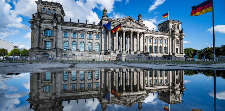 El edificio del Reichstag, sede de la cámara baja del parlamento alemán, se refleja en un charco tras un diluvio en Berlín.