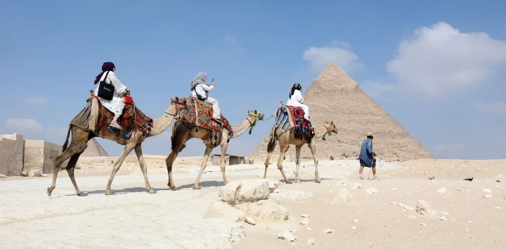 Imagen de turistas visitando el punto escénico de las Pirámides de Giza, en Giza, Egipto.