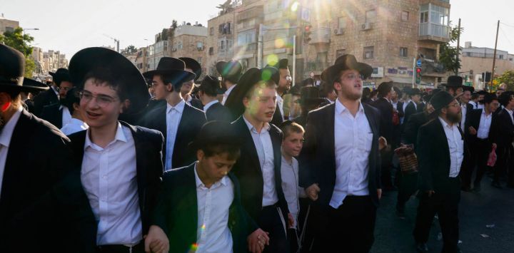 Manifestantes judíos ultraortodoxos corean cánticos tomados de la mano mientras protestan por su reclutamiento en el ejército israelí y el arresto de estudiantes de escuelas religiosas que evadieron las órdenes de reclutamiento, durante una manifestación en Jerusalén.