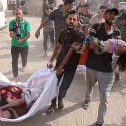 Hombres palestinos transportan los cuerpos de los niños de la familia Irhim, asesinados en un ataque israelí en el distrito de Zaitun, al hospital Al-Shifa de la ciudad de Gaza. | Foto:Bashar Taleb / AFP