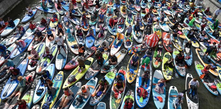 Imagen de entusiastas asistiendo al desfile de SUP (surf de remo), en Moscú, Rusia.