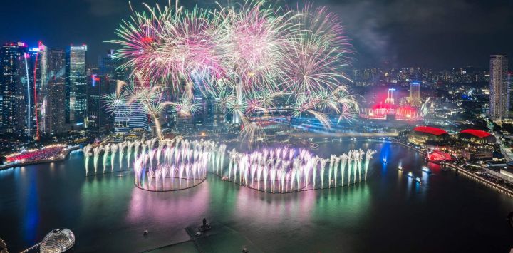Imagen de fuegos artificiales iluminando el cielo sobre Marina Bay durante las celebraciones del Día Nacional, en Singapur.