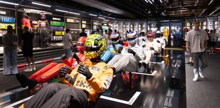 Imagen de visitantes observando trajes de carrera de Fórmula 1 durante la "Exposición de la Fórmula 1", en Amsterdam, Países Bajos.