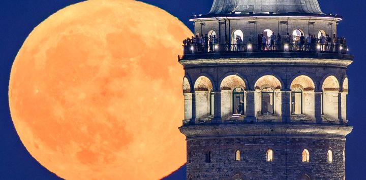La luna creciente se alza sobre la Torre de Gálata en Estambul, Turquía.