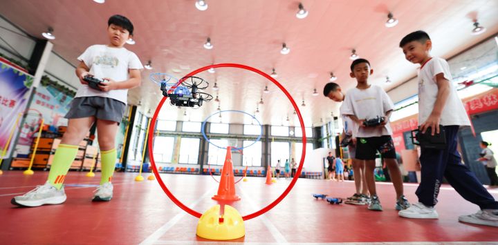 Niños juegan a controlar minidrones, en la ciudad de Jinzhou, en la provincia de Hebei, en el norte de China. Niños de toda China participan en diversas actividades para pasar el verano.