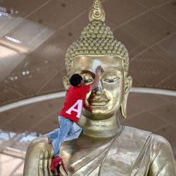 Un trabajador limpia una estatua de Buda en el recién construido Aeropuerto Internacional de Techo, en la provincia de Kandal, Camboya. | Foto:TANG CHHIN SOTHY / AFP