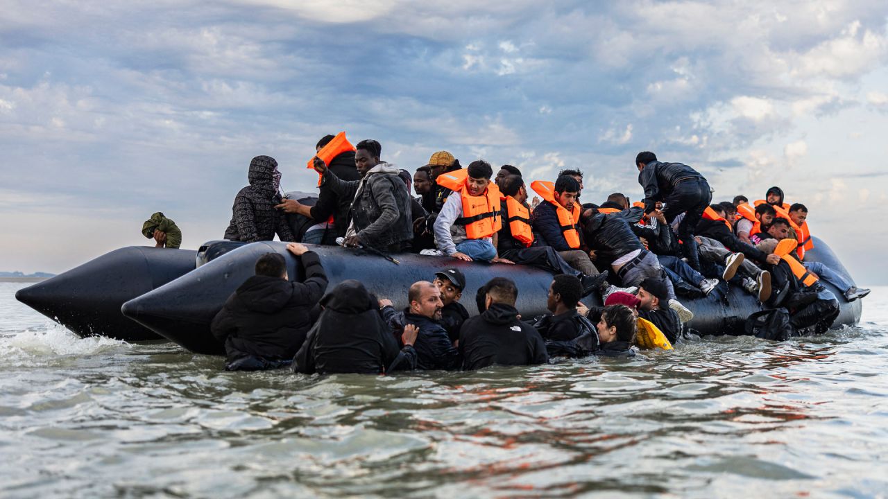 Migrantes intentan subir a un barco de contrabandistas para intentar cruzar el Canal de la Mancha frente a la playa de Gravelines, en el norte de Francia. | Foto:SAMEER Al-DOUMY / AFP