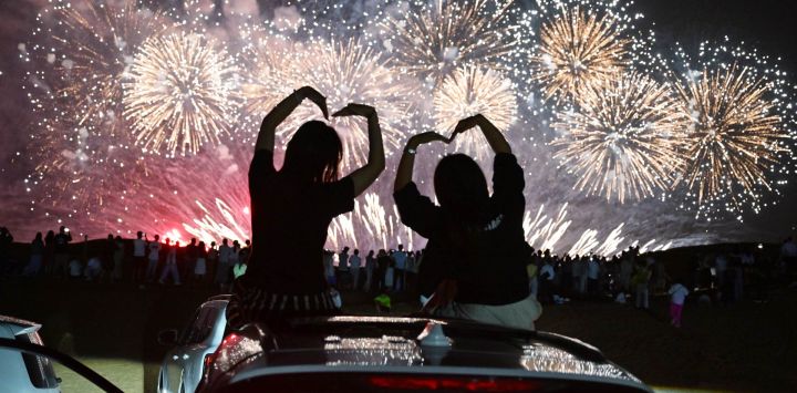 Imagen de turistas observando un espectáculo de fuegos artificiales, en el distrito de Shapotou de Zhongwei, en la región autónoma hui de Ningxia, en el noroeste de China.