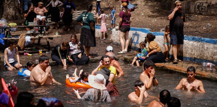 Israelíes se refrescan en el manantial de Ein El Alamein, cerca de la ciudad de Had Nes, en los Altos del Golán anexionados por Israel, durante las vacaciones de verano en uno de los días más calurosos de la temporada.
