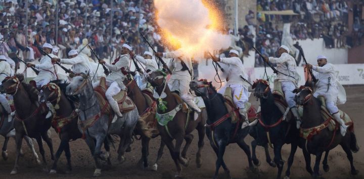Jinetes marroquíes disparan sus rifles durante una exhibición ecuestre de Tbourida, en el marco del festival anual de Moussem, que celebra el patrimonio cultural y atrae a miles de asistentes, en El Yadida.