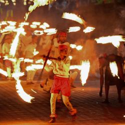 Niños bailan la danza del fuego frente al histórico Templo Budista del Diente, como parte de las celebraciones del festival budista de Esala Perahera, en la antigua capital montañosa de Kandy, Sri Lanka. | Foto:ISHARA S. KODIKARA / AFP