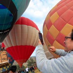 Una mujer graba con un teléfono móvil un globo aerostático mientras se eleva durante el cuarto Festival Internacional del Globo Mitad del Mundo, en la ciudad de Quito, capital de Ecuador. | Foto:Xinhua/Ricardo Landeta