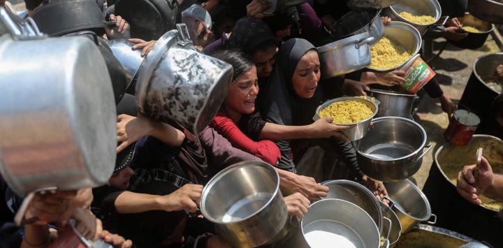 Imagen de palestinos desplazados esperando para recibir alimentos gratuitos, en el oeste de la Ciudad de Gaza.
