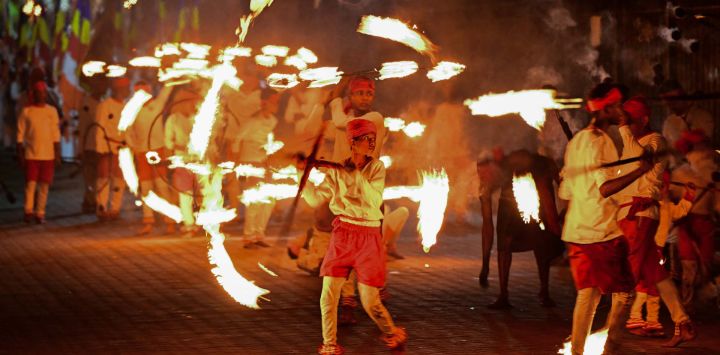 Niños bailan la danza del fuego frente al histórico Templo Budista del Diente, como parte de las celebraciones del festival budista de Esala Perahera, en la antigua capital montañosa de Kandy, Sri Lanka.