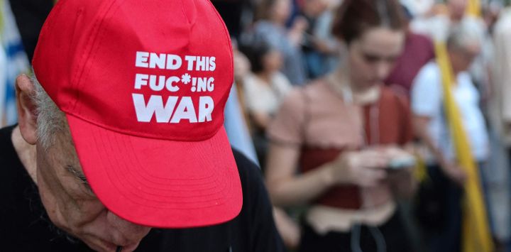 Un hombre con una gorra con un lema antibélico se encuentra durante una manifestación de pilotos retirados y de reserva de la Fuerza Aérea Israelí, que exigen el fin inmediato de la guerra y medidas urgentes para repatriar a los rehenes cautivos en Gaza desde octubre de 2023.